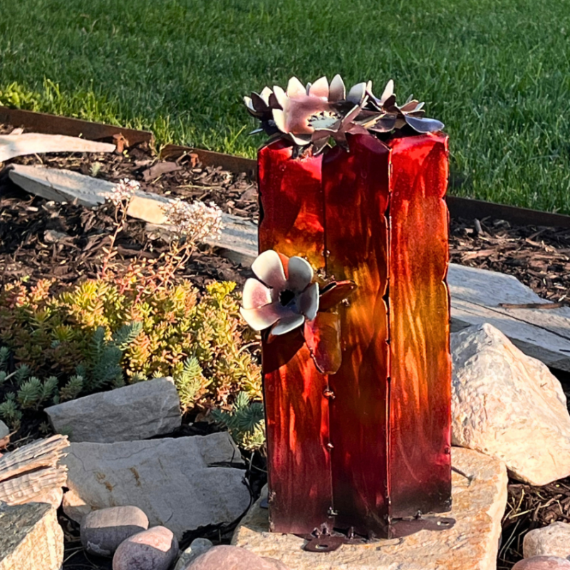 Decorative metal sculpture with floral designs on a natural background