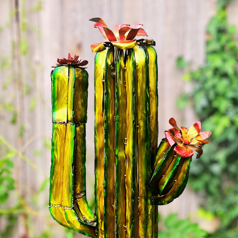 Close up of tall cactus sculpture with flowers on a blurred garden background