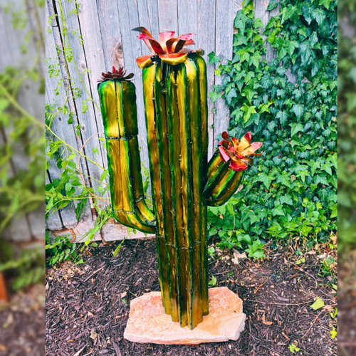 Decorative cactus sculpture with flowers in a garden setting
