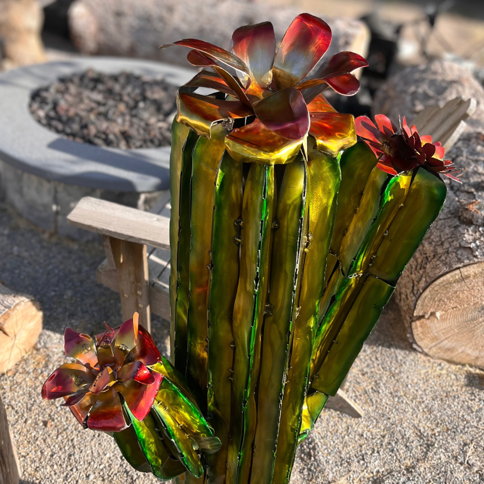 Top view of Decorative metal cactus with red flowers in an outdoor setting