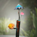 Decorative garden stake with colorful mushrooms and an umbrella-like top against a blurred green background