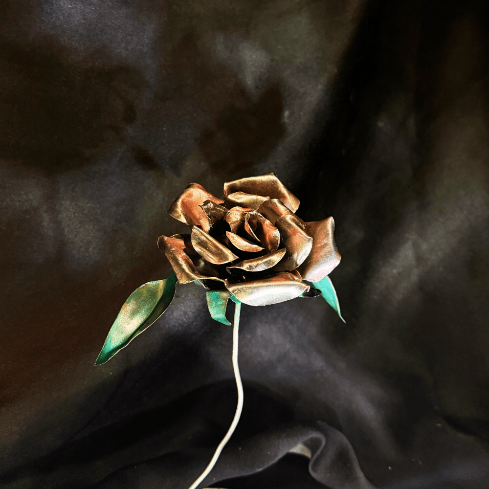 Metallic metal rose on a dark fabric background