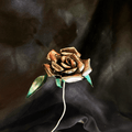 Metallic metal rose on a dark fabric background