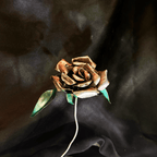 Metallic metal rose on a dark fabric background
