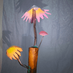 Artistic representation of mushrooms with a wooden base against a blurred gray background