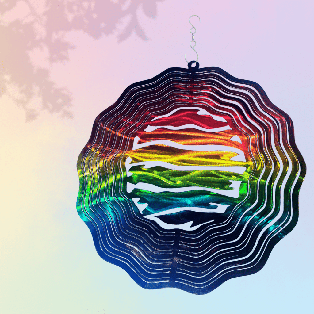 Colorful geometric wind spinner with a gradient of colors on a soft, multicolored background.