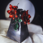 Decorative vase with red flowers and green leaves on a textured surface