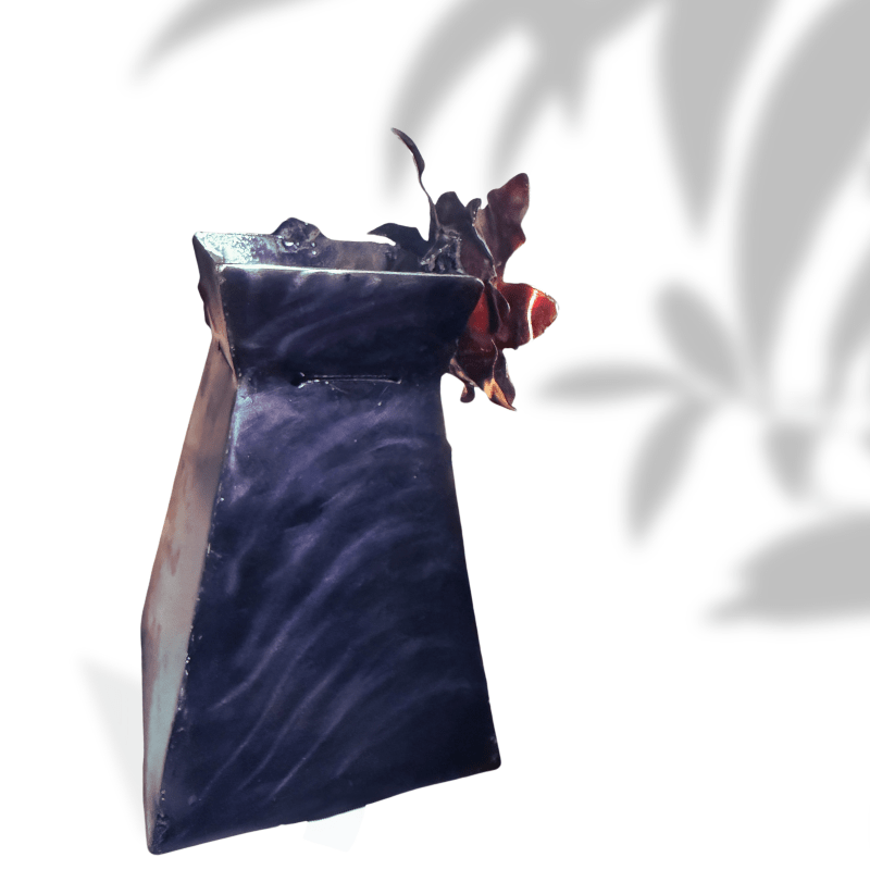 Decorative metal vase art with wavy black design on a white background