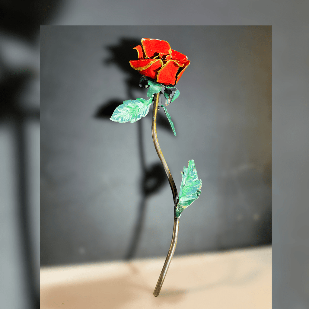 Decorative red rose with green leaves on a gray background