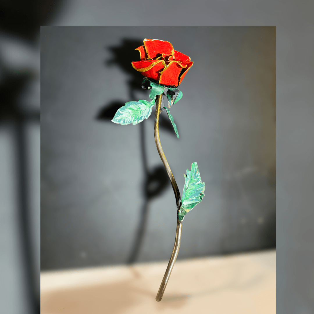Decorative red rose with green leaves on a gray background