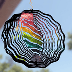 Colorful wind spinner with a rainbow pattern against a blurred outdoor background