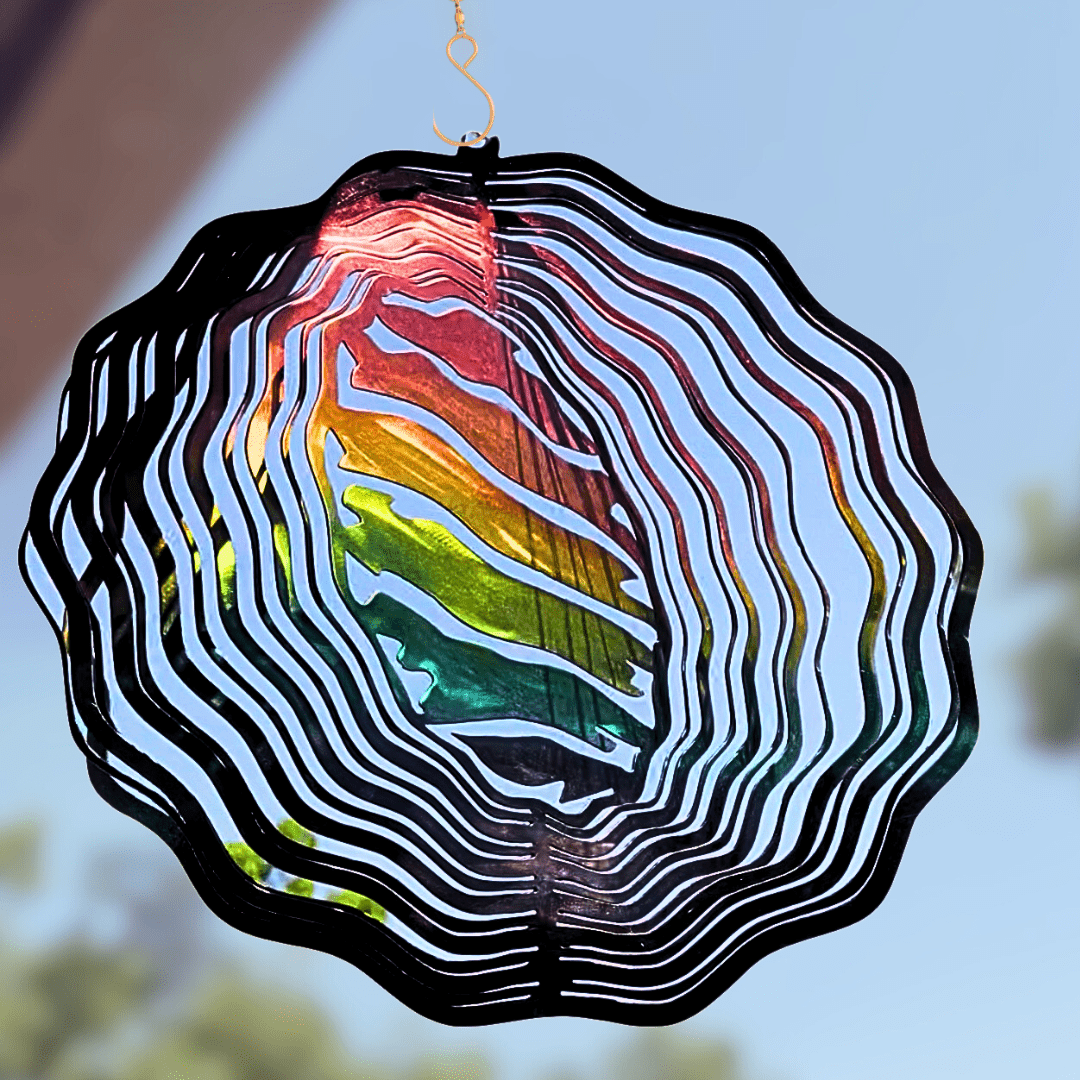 Colorful wind spinner with a rainbow pattern against a blurred outdoor background