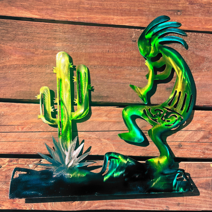 Metal sculptures of a cactus and a Kokopelli figure on a wooden surface