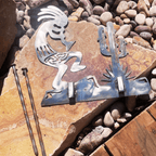 Metal sculpture of a Native American figure with a cactus on a stone surface